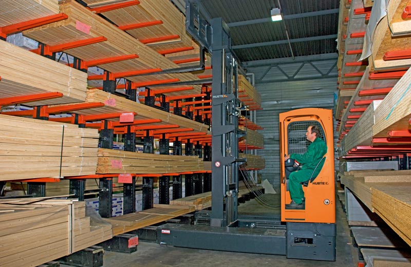 Man on man-up order picker picking extrusions off a cantilever rack system